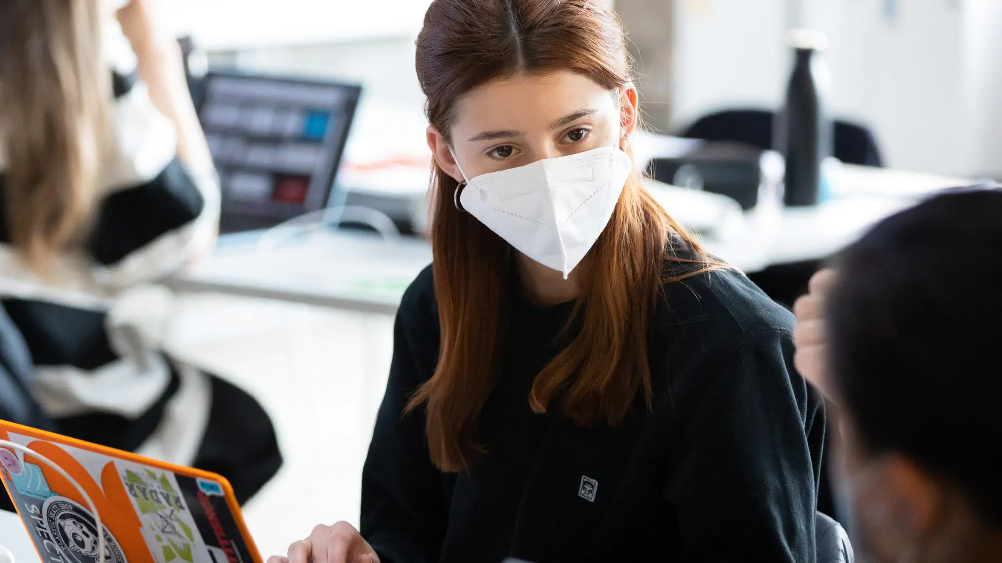 IAAD University student wearing a face mask using a laptop during an Interior design lesson